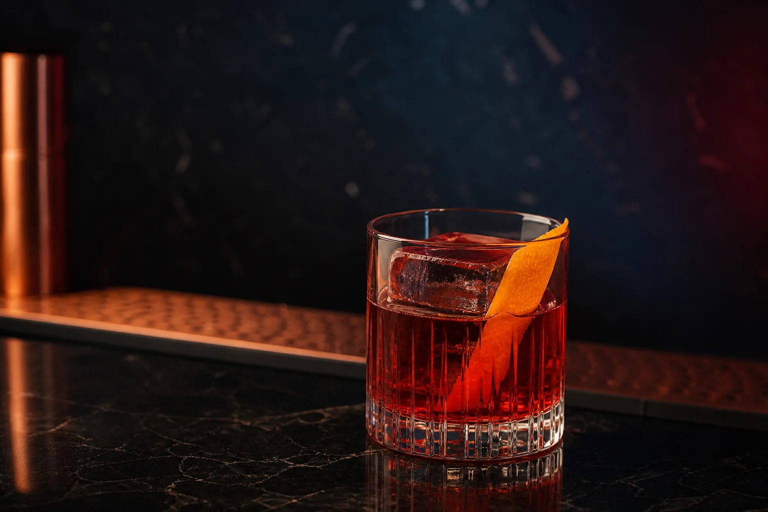 Negroni CAPICÚA en vaso bajo, con hielo y piel de naranja.