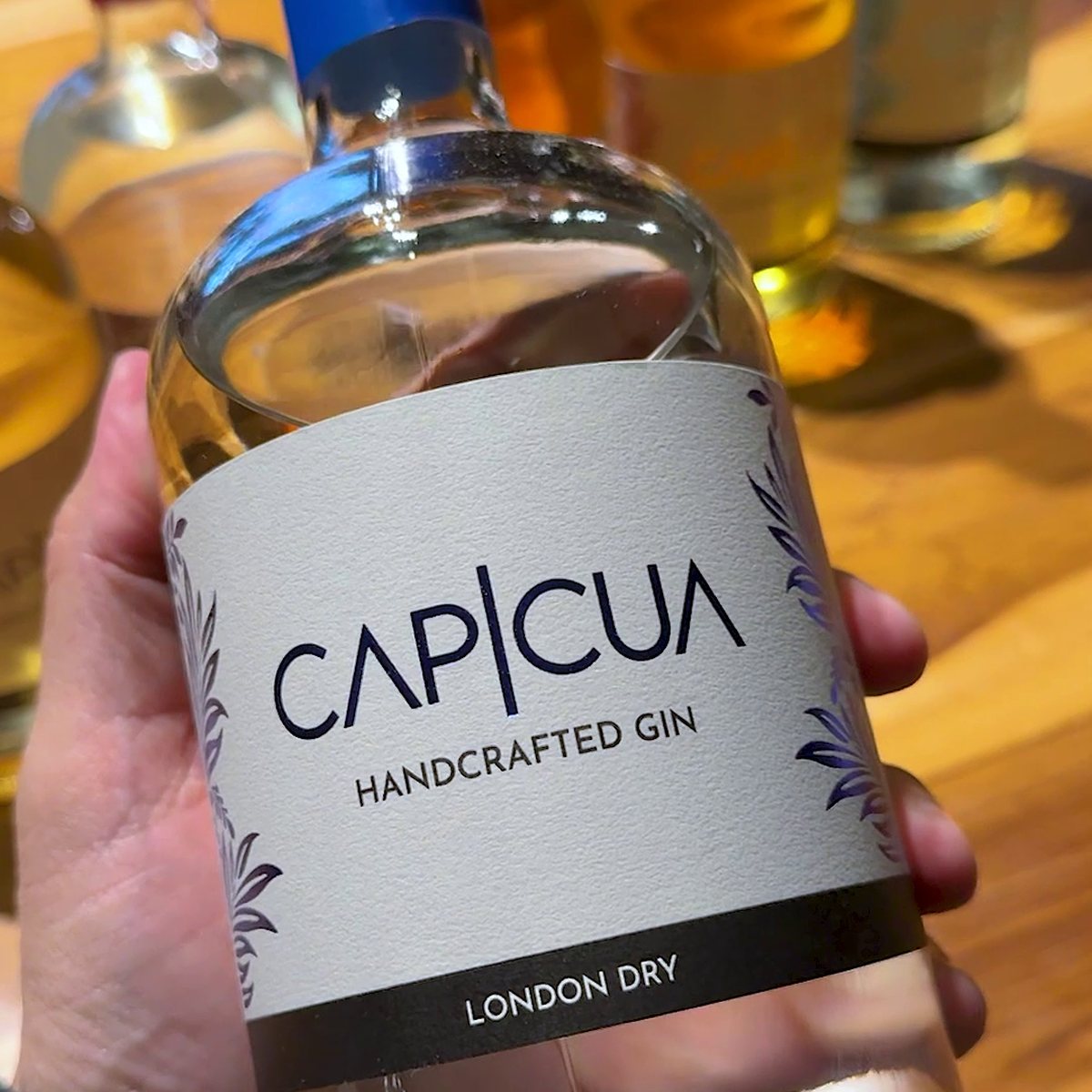 Botella CAPICÚA London Dry exhibida en una vinoteca