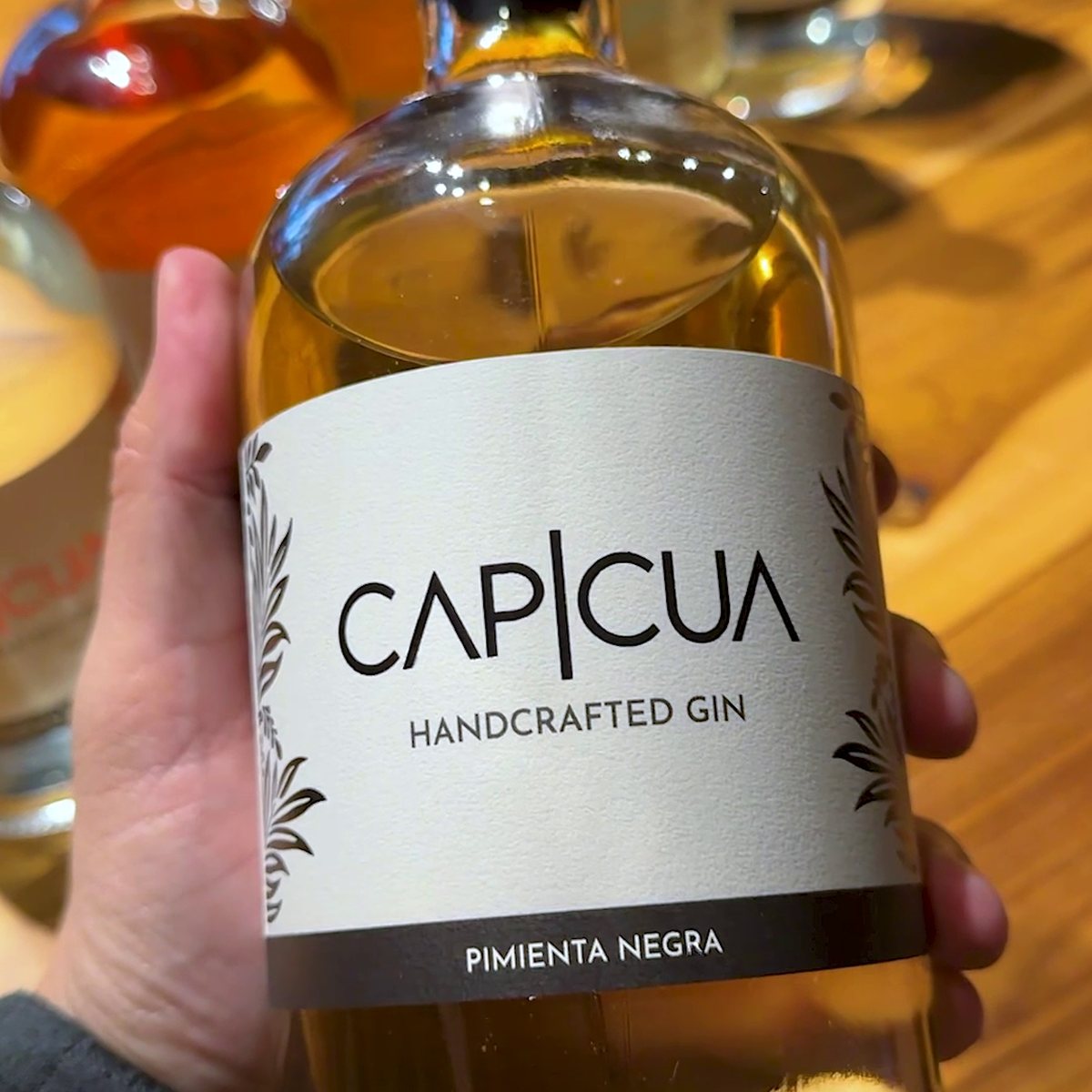 Botella CAPICÚA Pimienta Negra exhibida en una vinoteca