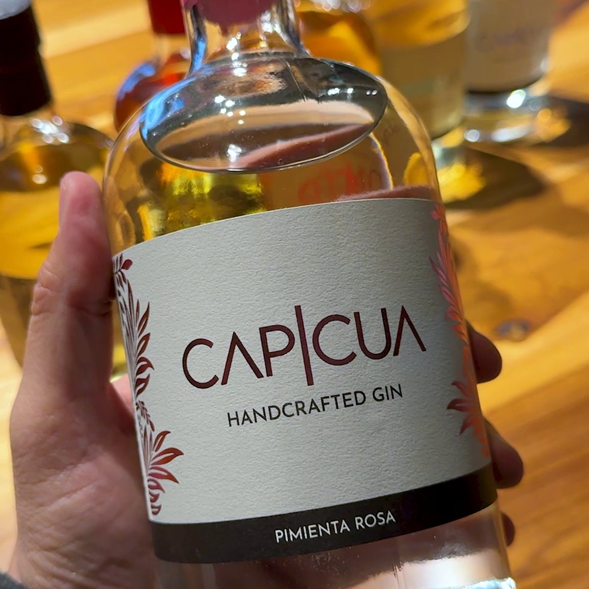 Botella CAPICÚA Pimienta Rosa exhibida en una vinoteca